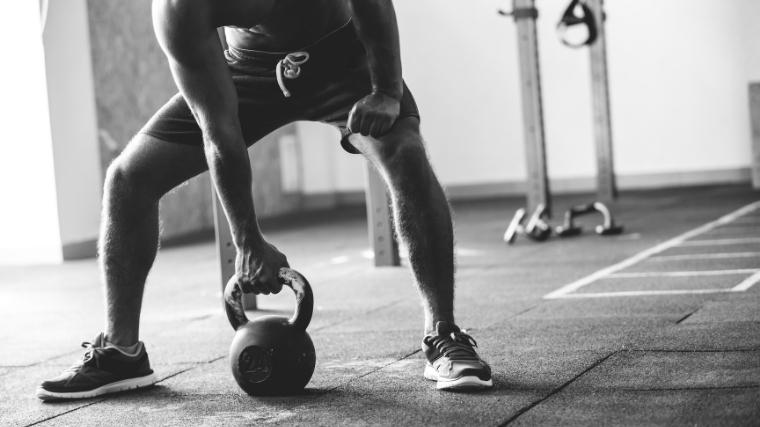 man holding a kettlebell in the gym