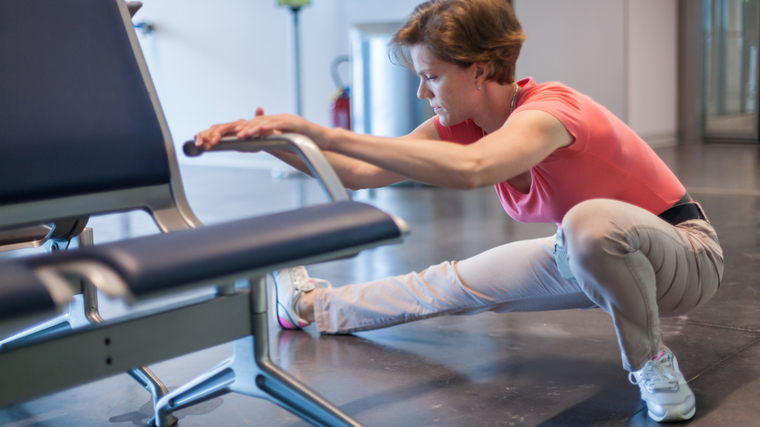 woman stretching hamstring at airport