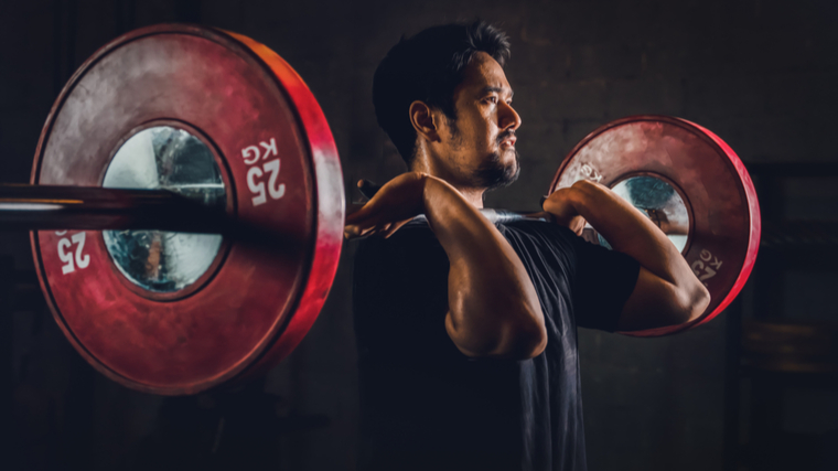 A person front racks a barbell.