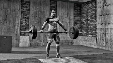 MAn performing a snatch exercise using a hook grip