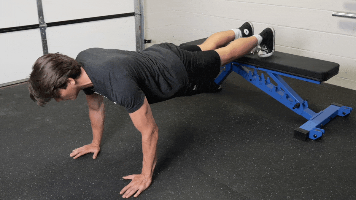 A person performing the decline push-up exercise.