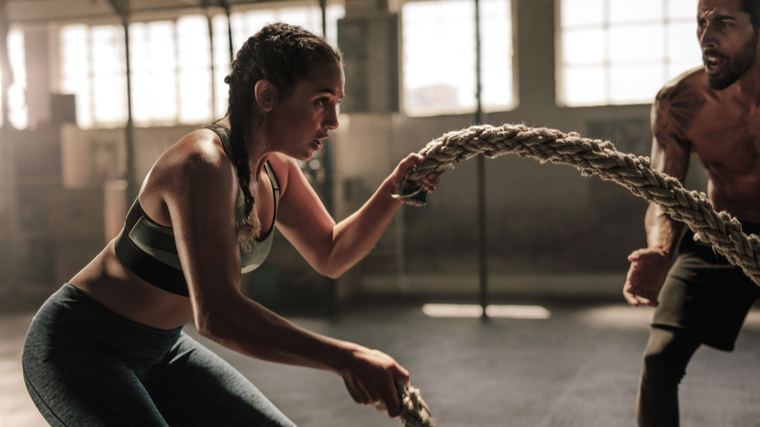 woman swinging battle rope