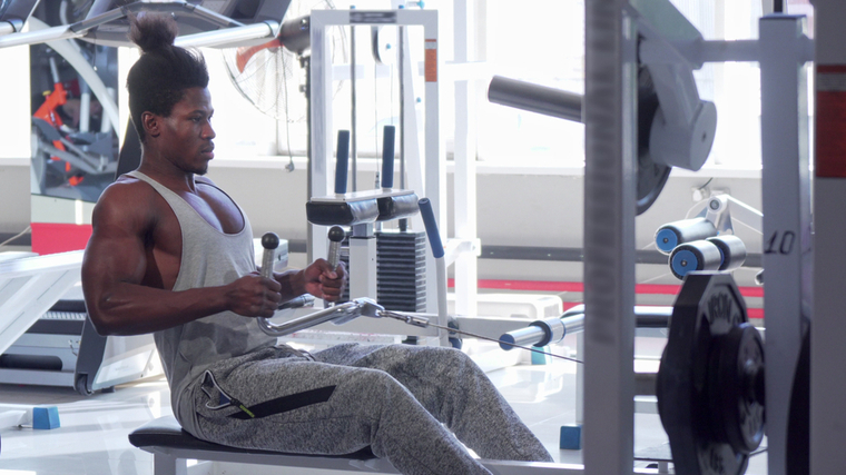 A person performs a seated cable row in the gym.