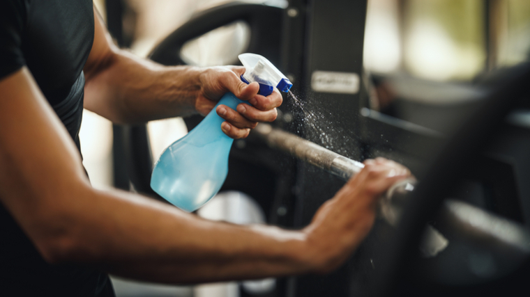 man wiping down barbell 