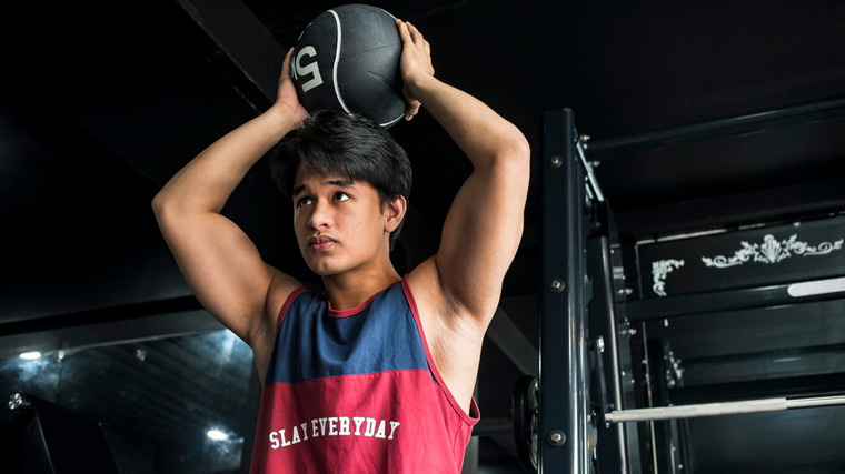 A person prepares to perform a medicine ball slam.