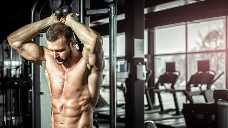 A person prepares to perform an overhead triceps cable extension.