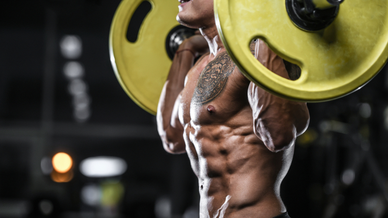 A close-up shot shows a shirtless person with a barbell on their back.