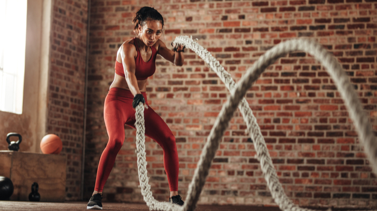 A person works out with battle ropes.