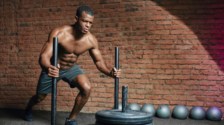 A person performs a sled push.