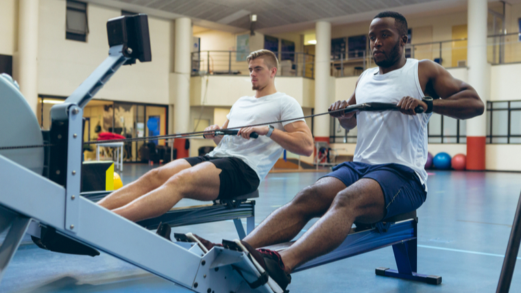 Two people row in the gym.