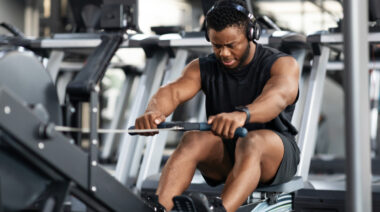 A person uses a rowing machine in the gym.