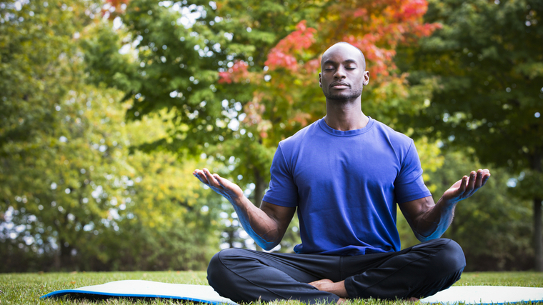 A person meditates in a park.