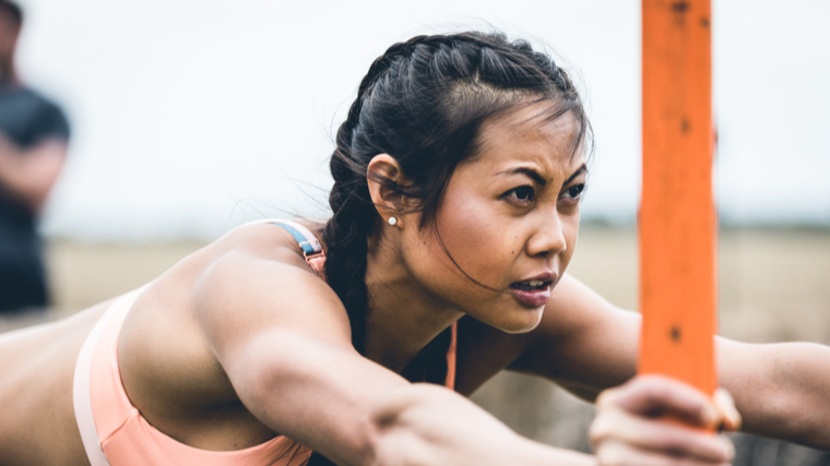 A person performs a sled push outside.