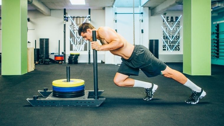 Man driving to push a weighted sled