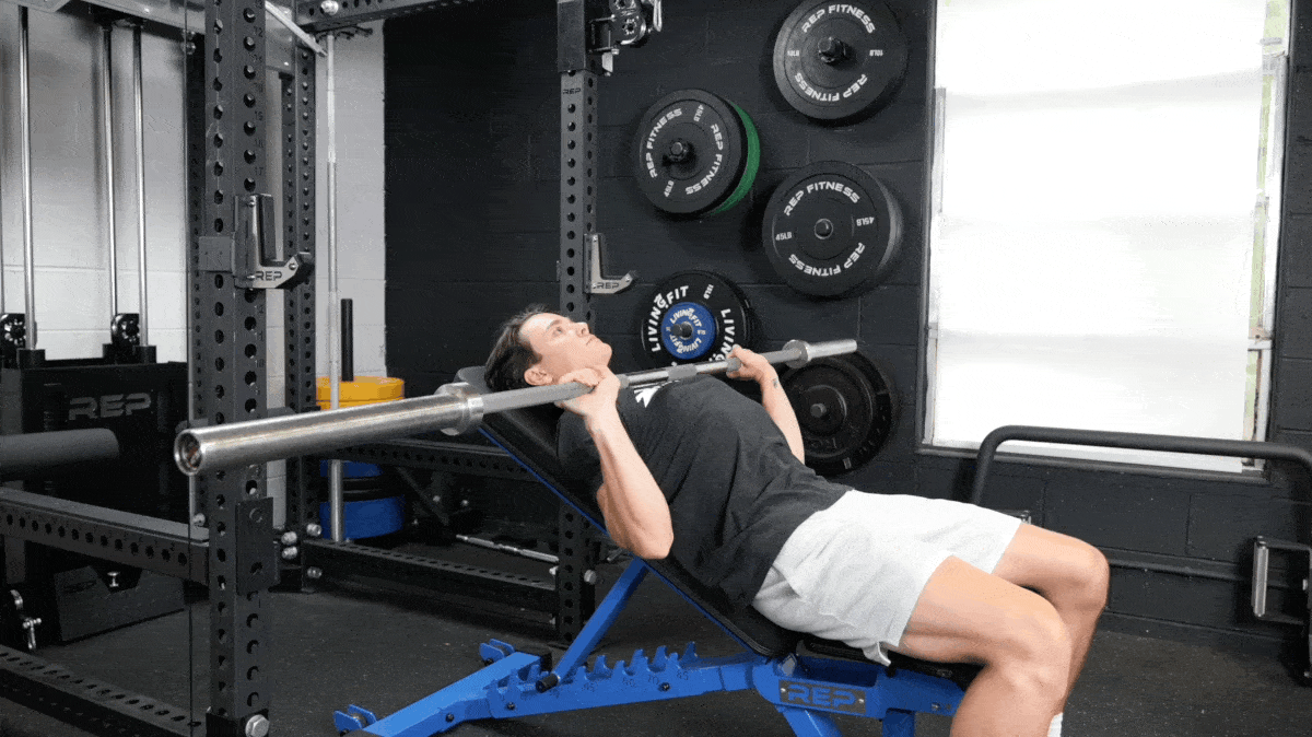 A person performing the incline barbell bench press