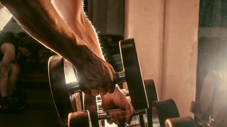 man grabbing dumbbell