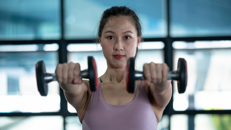 A person performs a dumbbell front raise.