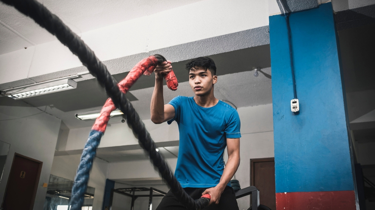 A person performs battle rope waves.