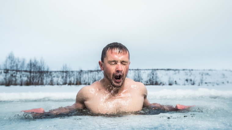 A person emerges from icy water.