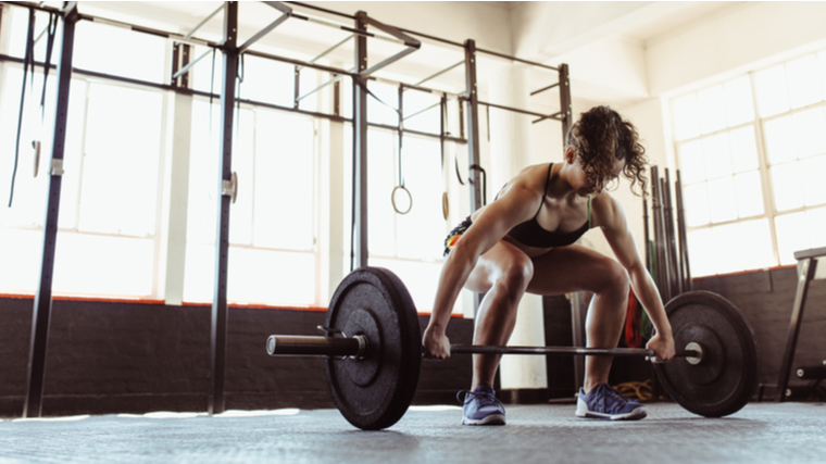 A person prepares to perform a barbell snatch.