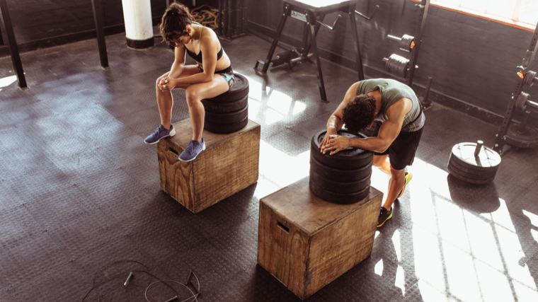 Zwei Fitnesspartner ruhen sich nach Boxsprüngen aus.