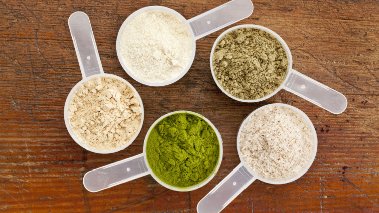 Five scoops of different types of protein powder.