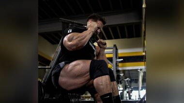bodybuilder Regan Grimes performing a squat using a hack squat machine