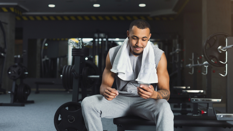 Water bottle, black man in gym and smartphone for social media