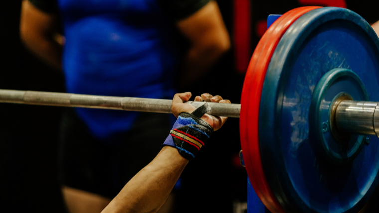 A close up of someone's hand while they prepare to bench press.