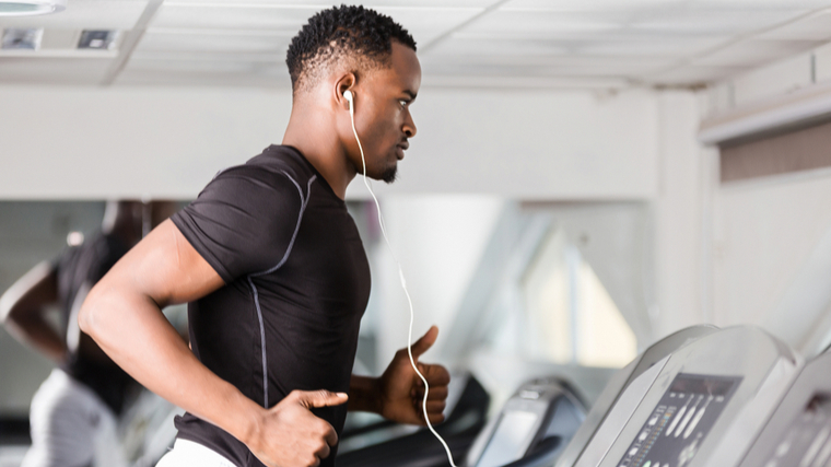 A person runs on a treadmill in the gym.