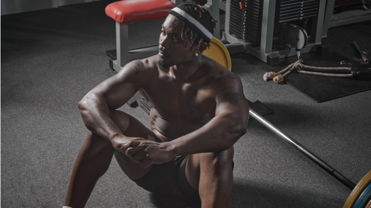 A person stares into the distance while resting in the gym.