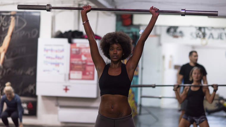 A person performs an overhead press.