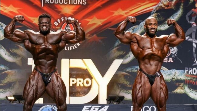 Blessing Awodibu posing next to Charles Griffen on stage at the 2022 Indy Pro Bodybuilding show