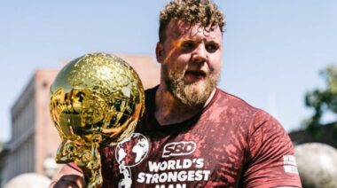 Strongman Tom Stoltman holding the 2021 World's Strongest Man Trophy