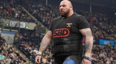 Strongman Andy Black wearing a black t-shirt with the letters "SBD" printed in red across it