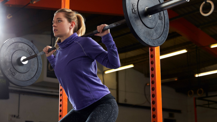 Woman Squatting with Barbell