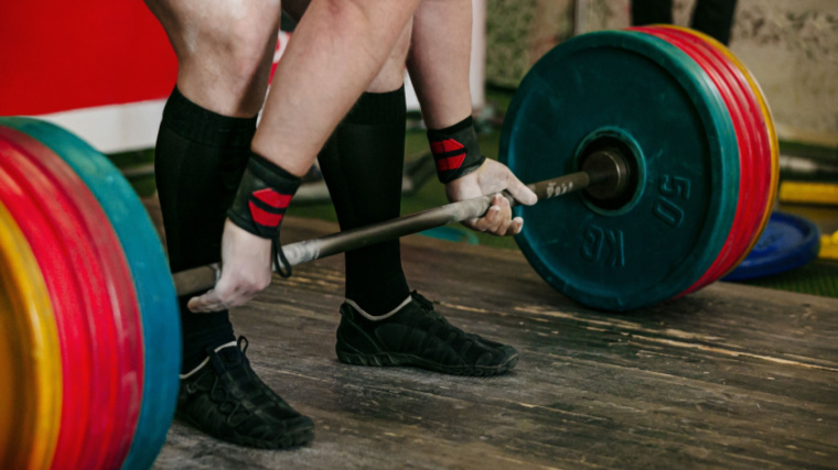 A powerlifter sets up with over-under grip for deadlift