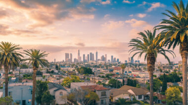 Beautiful sunset of Los Angeles downtown skyline and palm trees