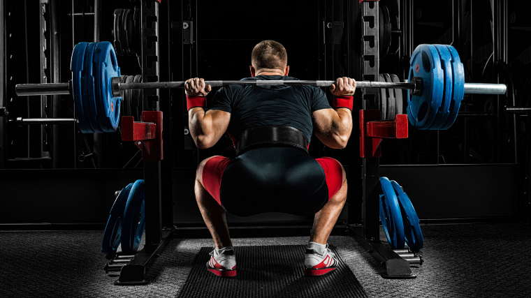 man squats in rack 