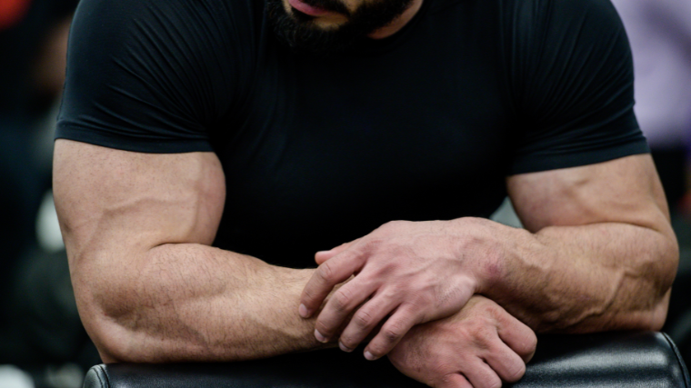 Man rests on his forearms during gym workout