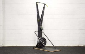 Concept2 SkiErg against a white brick wall on floor stand