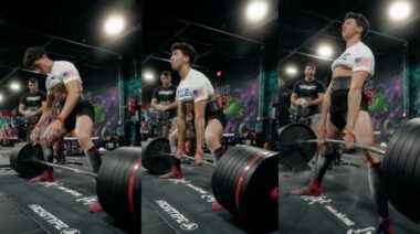 Person wearing a white t-shirt, black shirts, and red lifting shoes lifts a barbell loaded with 785 pounds of weight plates off of the floor.