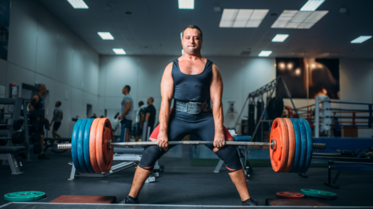 A powerlifter locks out a heavy sumo deadlift