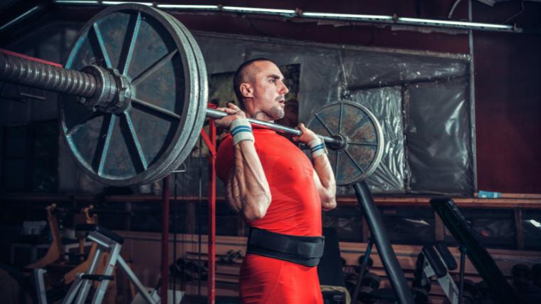 strength athlete sets up for overhead lift with steel plates