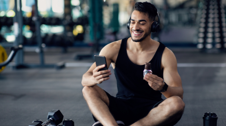 man enjoys intra-workout snack in gym