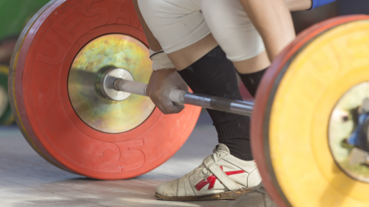 weightlifter grips loaded barbell