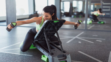 A person performs a dumbbell reverse flye on an incline bench.