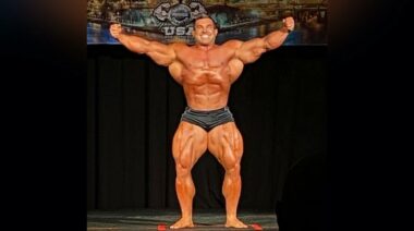 212 Olympia Champ Derek Lunsford posing on stage at the 2022 NPC Pittsburgh Pro
