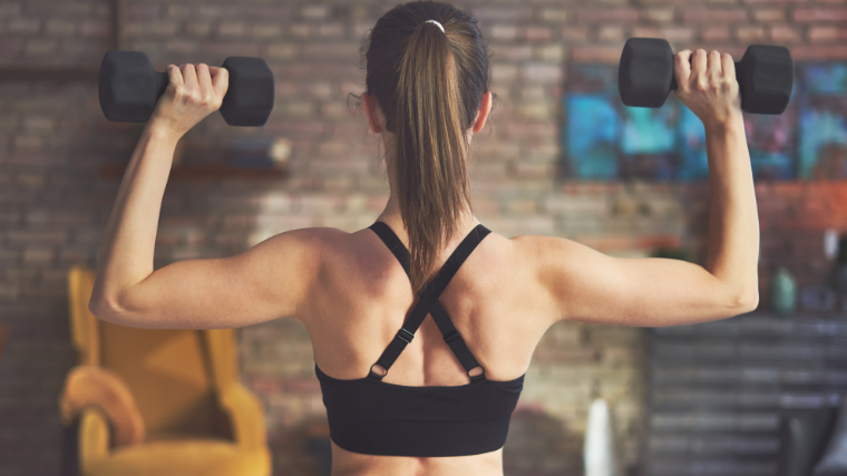 woman steadies dumbbells for overhead press 