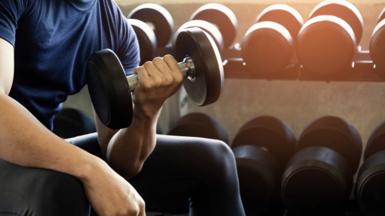 man performs concentration curl with dumbbell